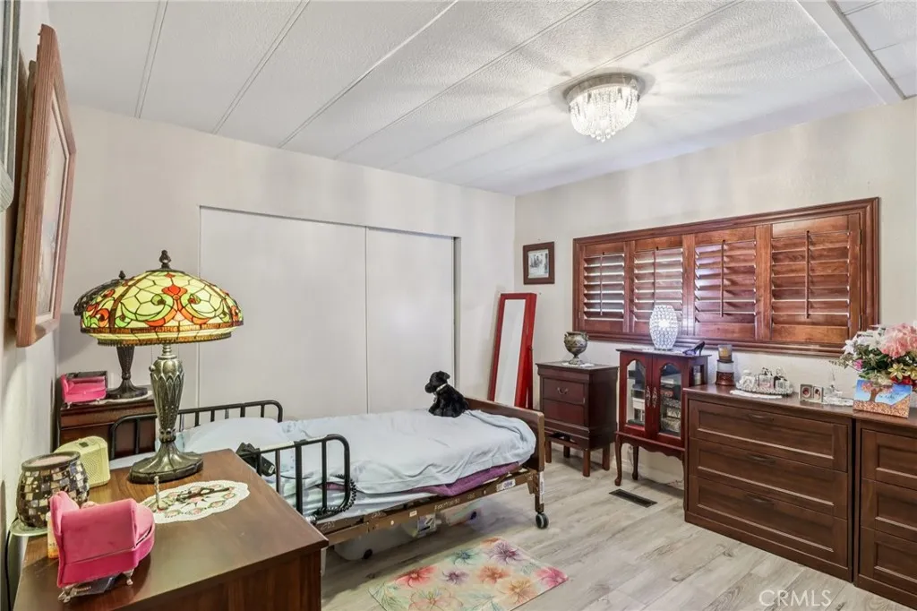 3700 Buchanan Street, Unit 28 Riverside, CA 92503 - Photo 23 of 35 a bedroom with a bed and a chandelier