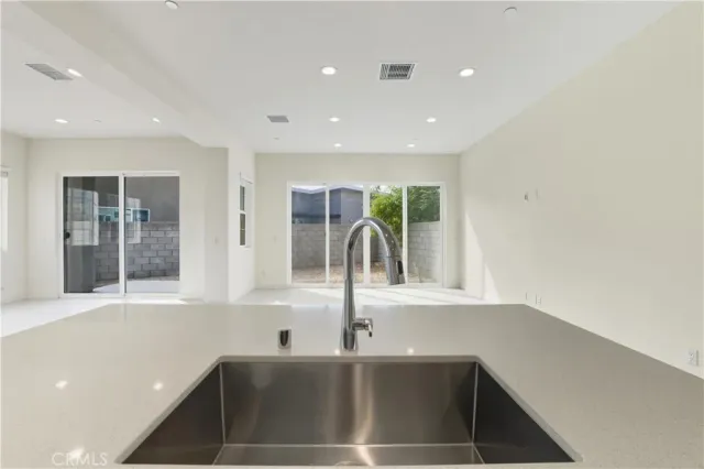 a view of a hallway with a refrigerator and a sink