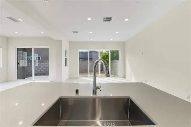 a view of a hallway with a refrigerator and a sink