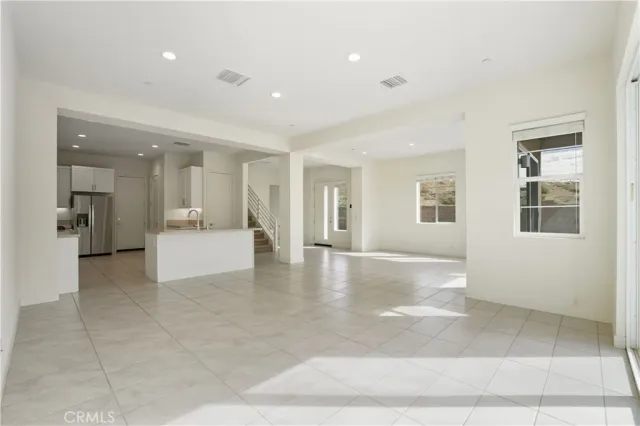 a kitchen with stainless steel appliances a refrigerator a stove a sink and white cabinets