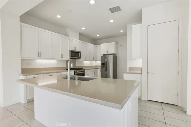 a kitchen with stainless steel appliances granite countertop a refrigerator and a sink