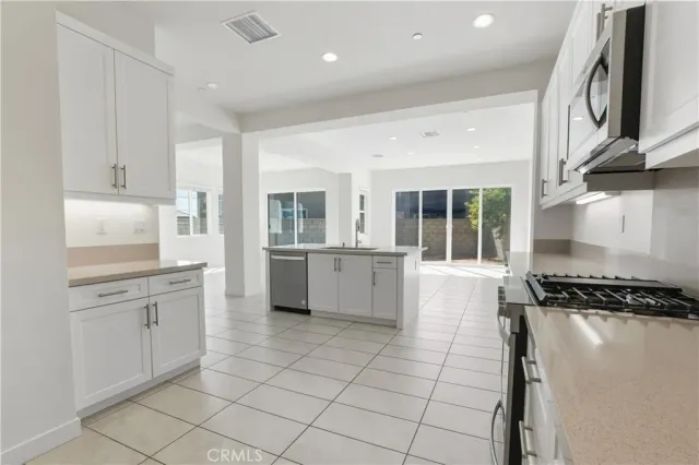a kitchen with white cabinets and stainless steel appliances