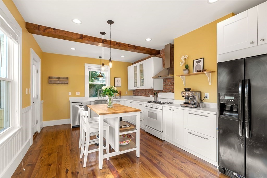 11 Hadwin Way Boston, MA 02131 - Photo 2 of 22 a kitchen with stainless steel appliances kitchen island granite countertop a stove a refrigerator a dining table and chairs with wooden floor