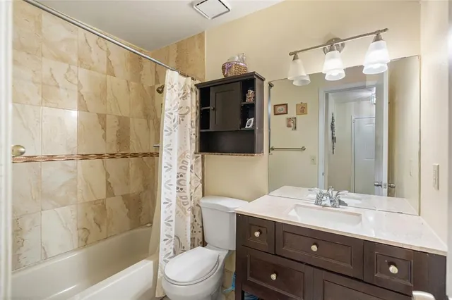 a bathroom with a sink vanity granite toilet and shower