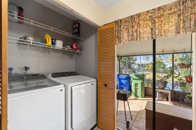 a utility room with dryer washer and a view of living area