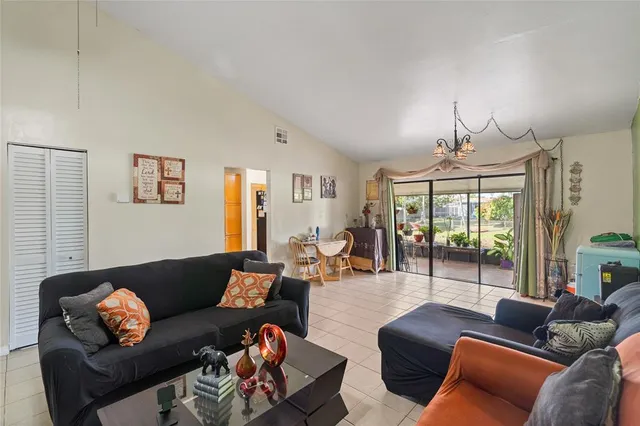 a living room with furniture a large window and a chandelier