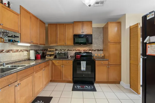 a kitchen with stainless steel appliances granite countertop a refrigerator and a stove top oven