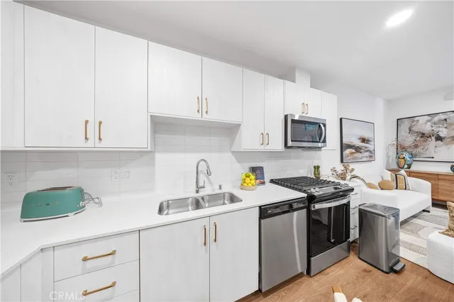 a kitchen with stainless steel appliances granite countertop white cabinets a sink and dishwasher