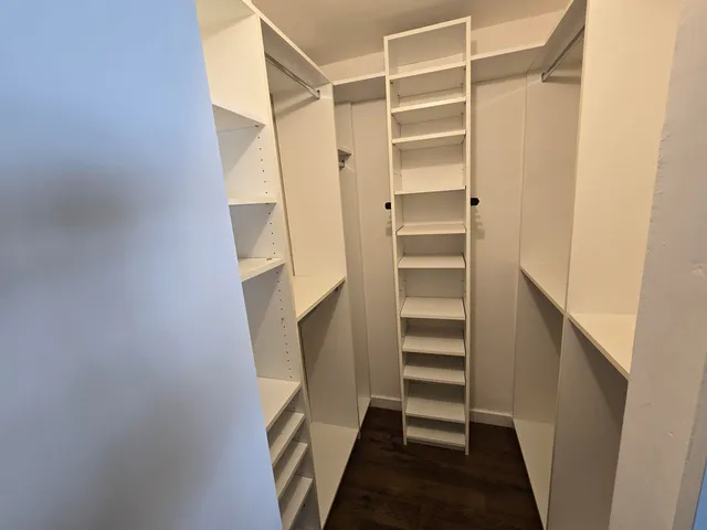 a view of walk in closet with empty racks
