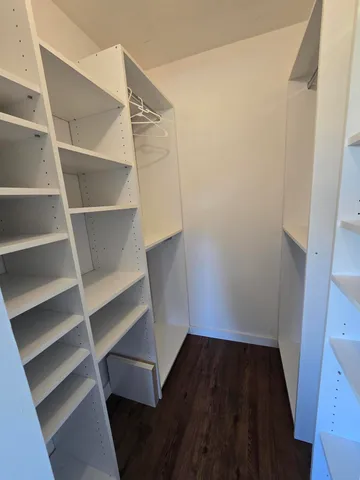 a view of walk in closet with empty racks