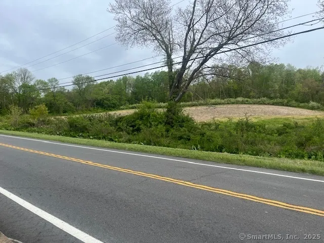 a view of a field with trees in the background