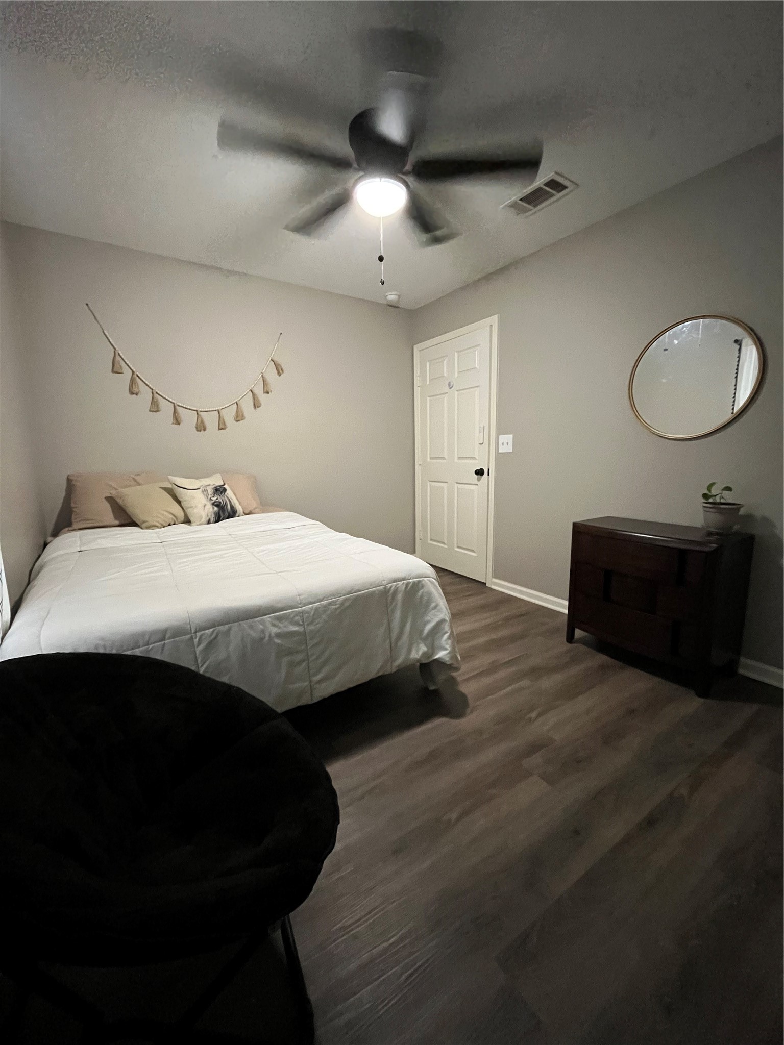 210 South Colbert Street Dayton, TX 77535 - Photo 7 of 14 a bedroom with a bed and a chandelier