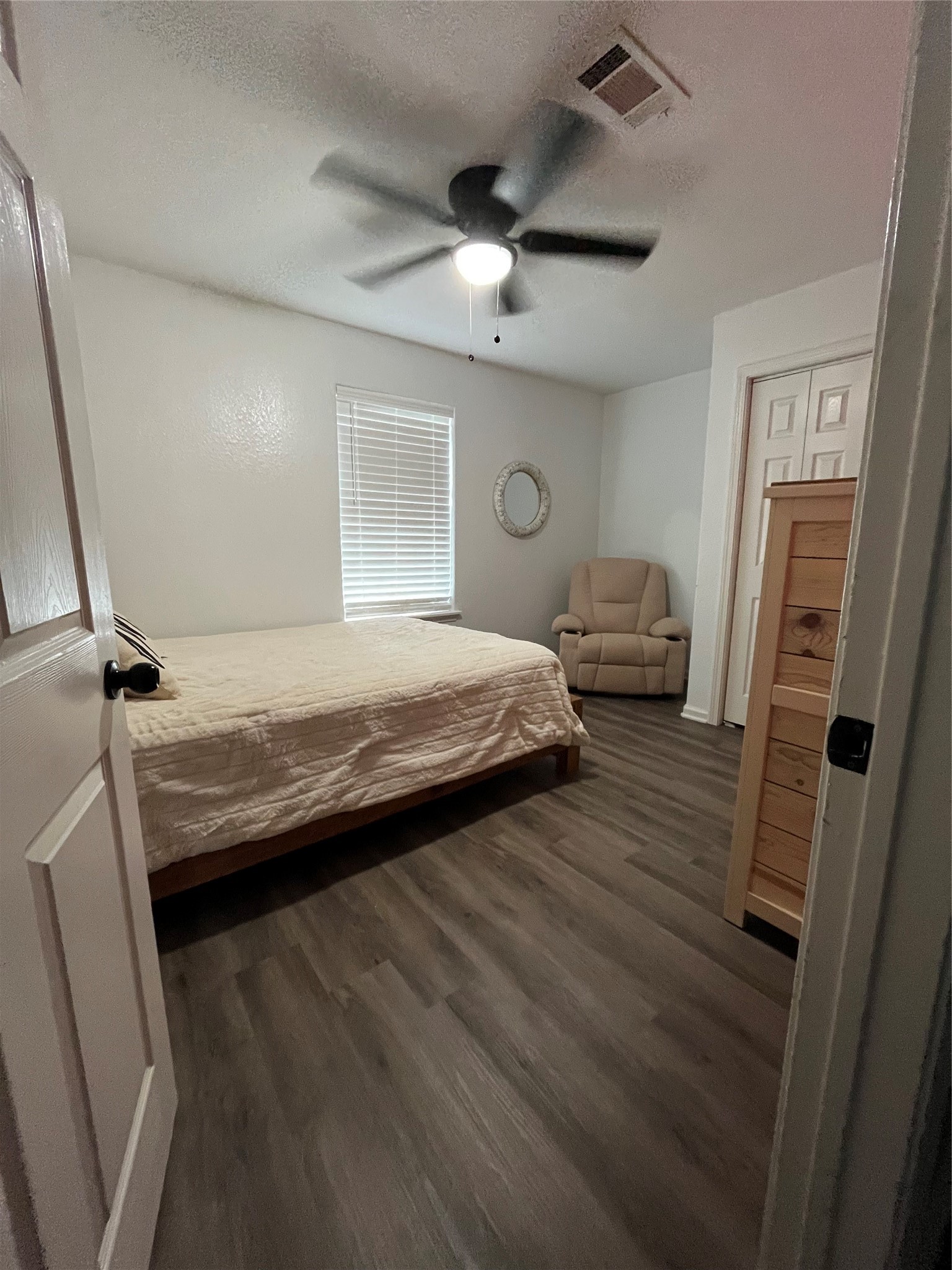 210 South Colbert Street Dayton, TX 77535 - Photo 8 of 14 a bedroom with a bed and a mirror on the dresser
