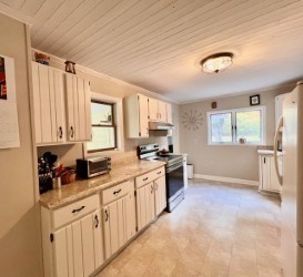 239 Pelham Road Amherst, MA 01002 - Photo 13 of 30 a large kitchen with stainless steel appliances a stove a sink a refrigerator and white cabinets