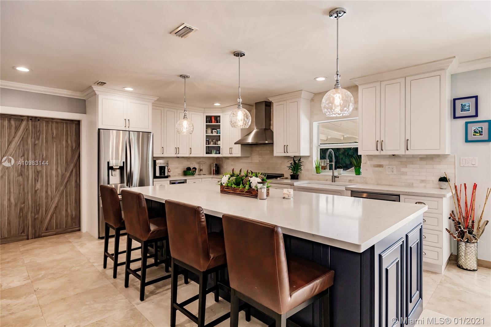 6400 Southwest 134th Drive Pinecrest, FL 33156 - Photo 16 of 50 a kitchen with a refrigerator a sink and a center island