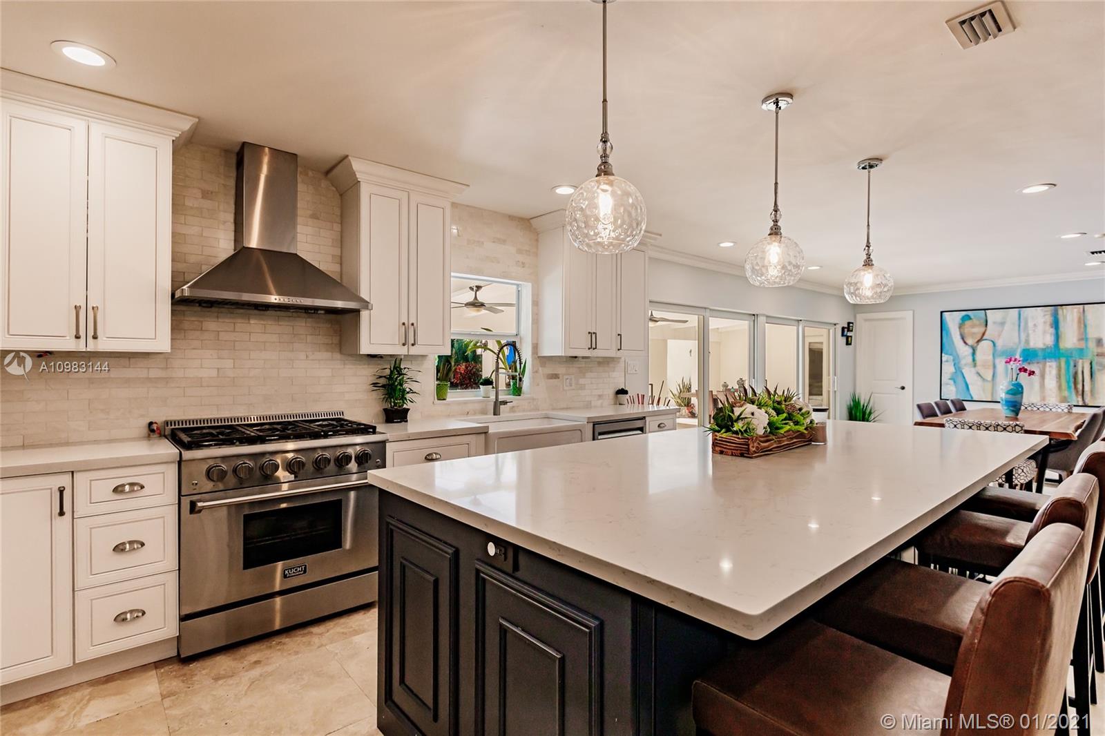 6400 Southwest 134th Drive Pinecrest, FL 33156 - Photo 17 of 50 a kitchen with a stove a sink a table and chairs