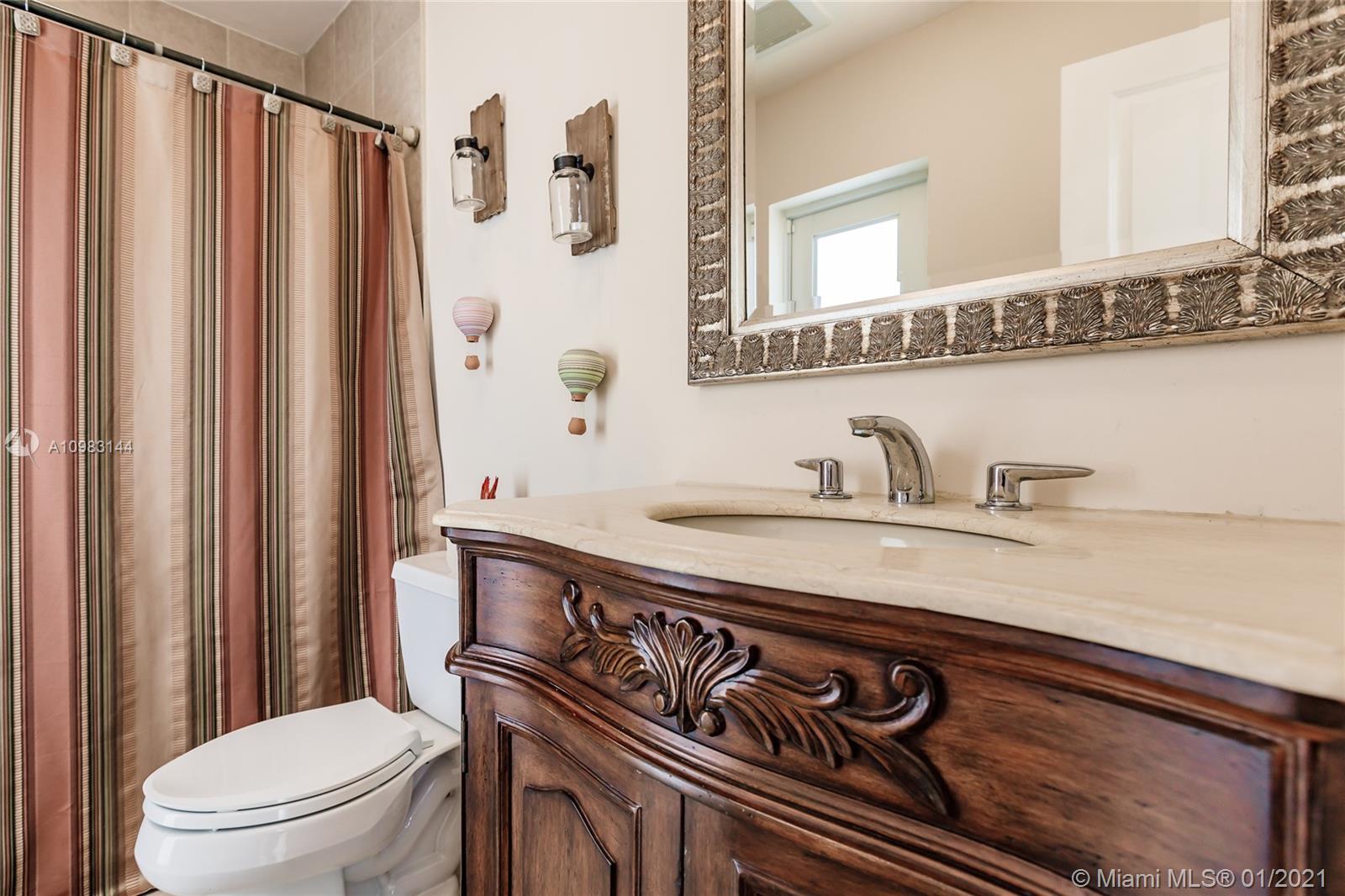 6400 Southwest 134th Drive Pinecrest, FL 33156 - Photo 27 of 50 a bathroom with a granite countertop sink toilet and mirror