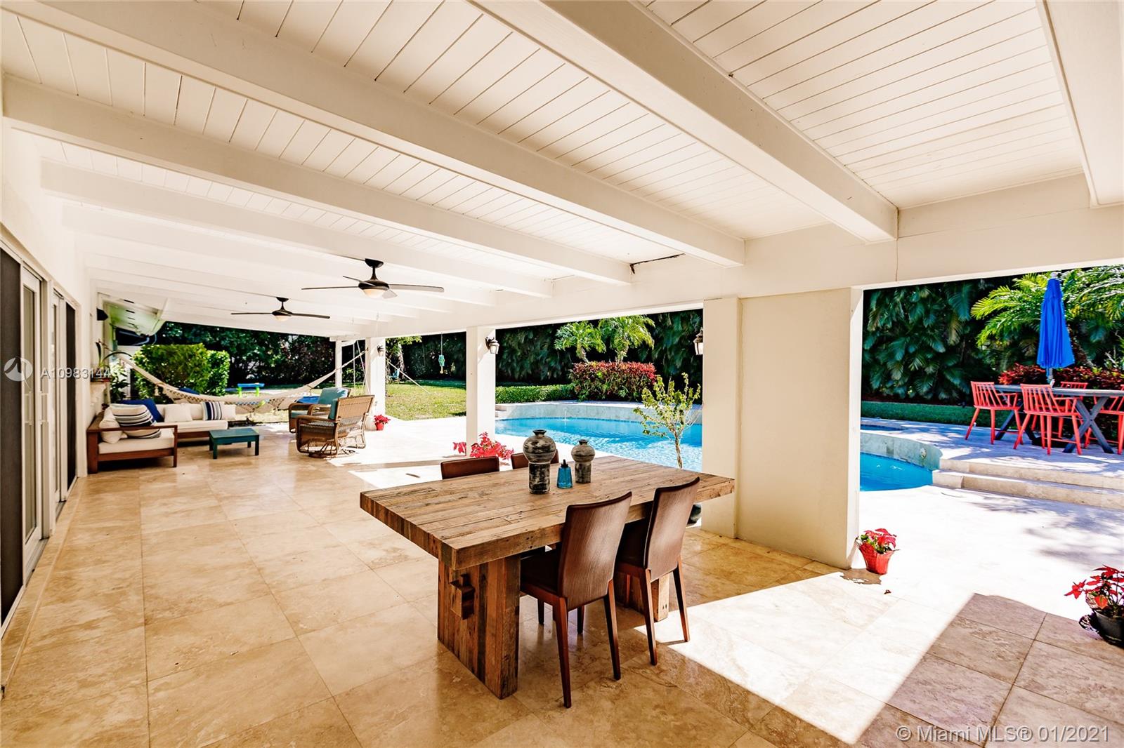 6400 Southwest 134th Drive Pinecrest, FL 33156 - Photo 40 of 50 a view of a patio with a dining table and chairs potted plants with large tree