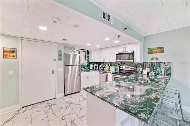 a kitchen with stainless steel appliances granite countertop a refrigerator and a stove top oven