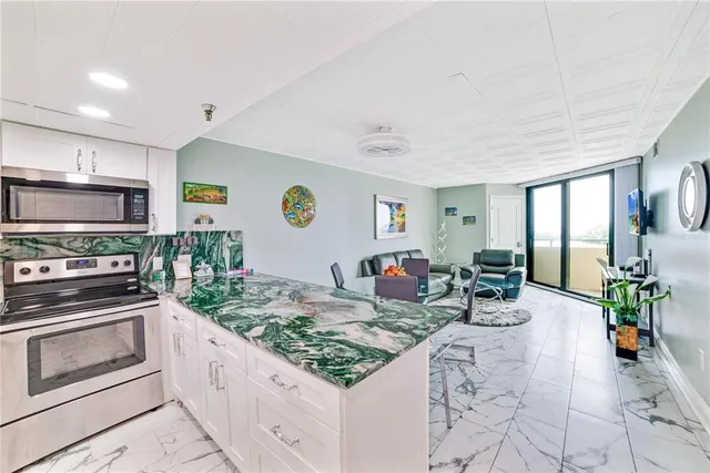 a kitchen with stainless steel appliances granite countertop a stove top oven a sink dishwasher and cabinets with wooden floor