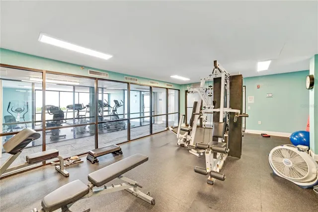 a room with lots of tables a large window and chairs