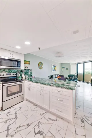 a kitchen with granite countertop cabinets and white appliances