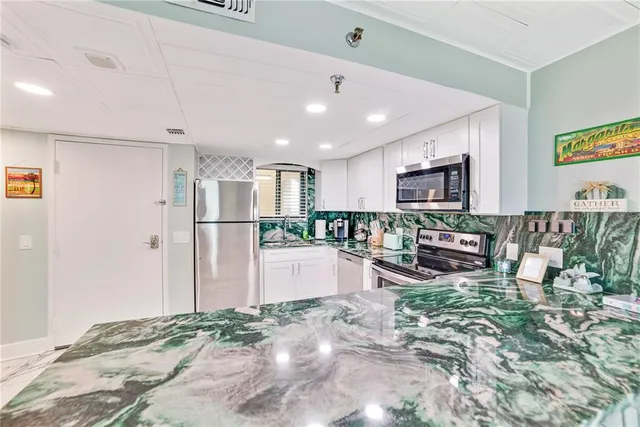 a view of a kitchen with refrigerator and chairs