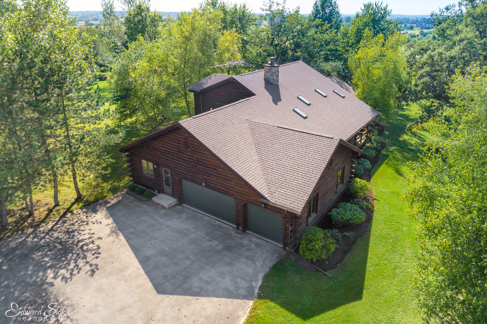 an aerial view of a house with a yard and large trees