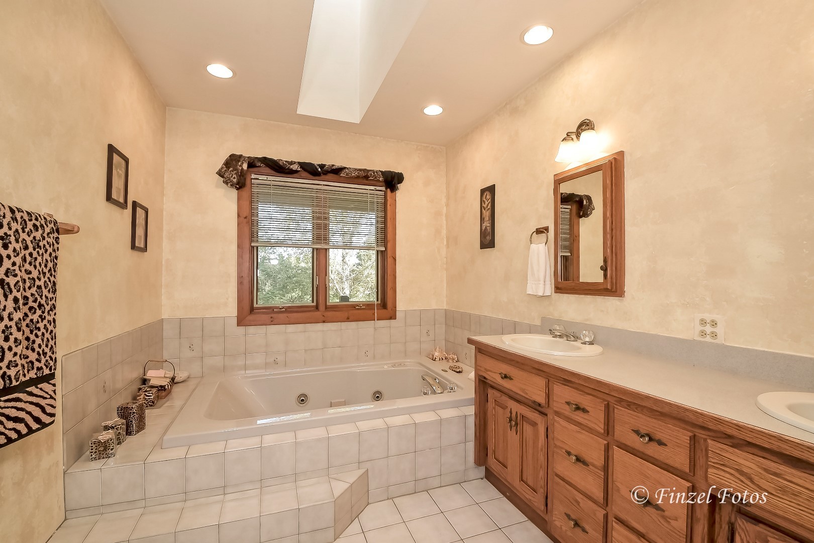 20619 Dunham Road Marengo, IL 60152 - Photo 9 of 31 a spacious bathroom with a double vanity sink a mirror and a bathtub