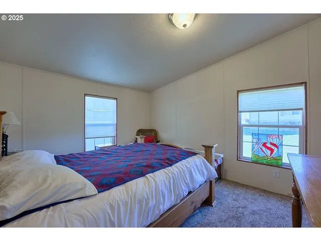 a bedroom with a bed and a painting on the wall