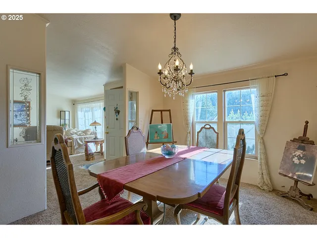 a view of a dining room with furniture a chandelier and wooden floor