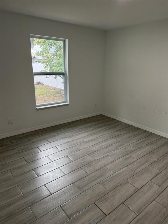 89 West Imogene Street Arcadia, FL 34266 - Photo 13 of 18 an empty room with wooden floor and windows