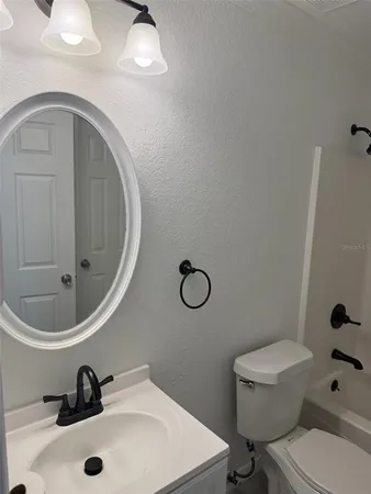 a bathroom with a sink mirror vanity and toilet