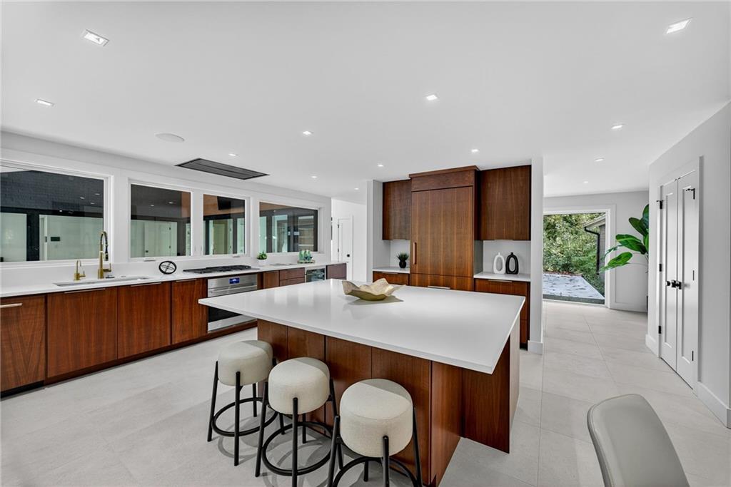 585 Amberidge Trail Northwest Atlanta, GA 30328 - Photo 29 of 103 a kitchen with stainless steel appliances granite countertop a table chairs sink and white cabinets