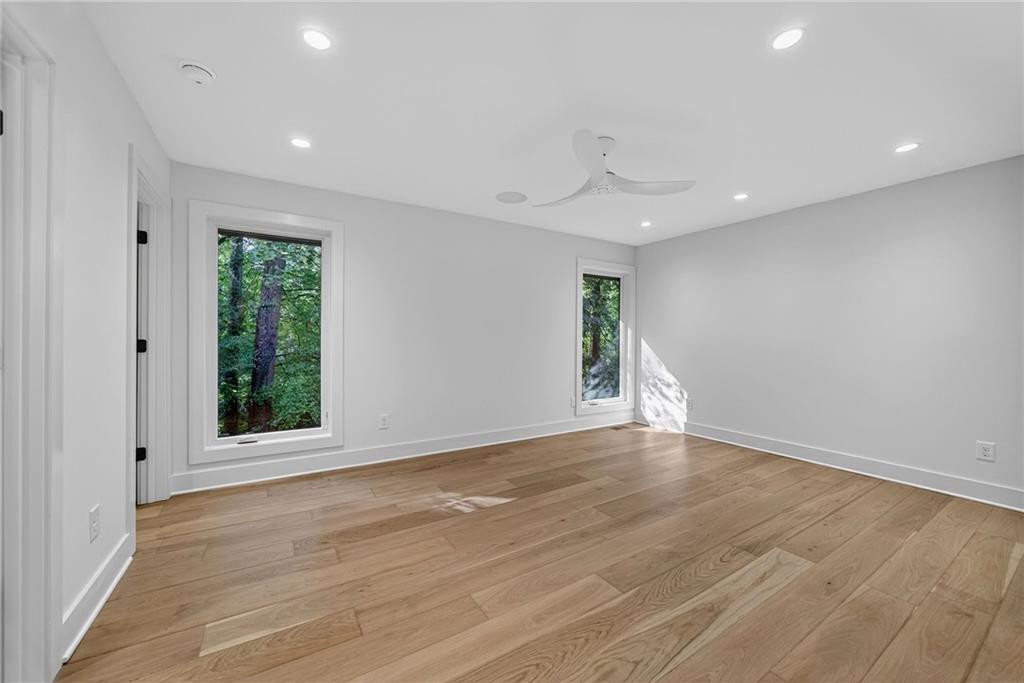 585 Amberidge Trail Northwest Atlanta, GA 30328 - Photo 48 of 85 a view of an empty room with wooden floor and a window