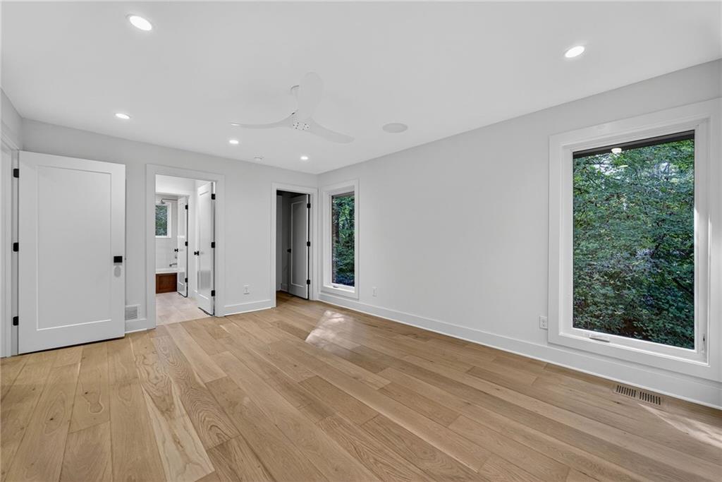 585 Amberidge Trail Northwest Atlanta, GA 30328 - Photo 53 of 103 a view of an empty room with wooden floor and a window