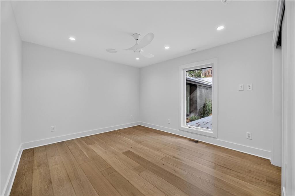 585 Amberidge Trail Northwest Atlanta, GA 30328 - Photo 62 of 103 a view of an empty room with wooden floor and a window