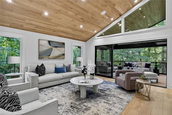 a living room with furniture fireplace and a large window