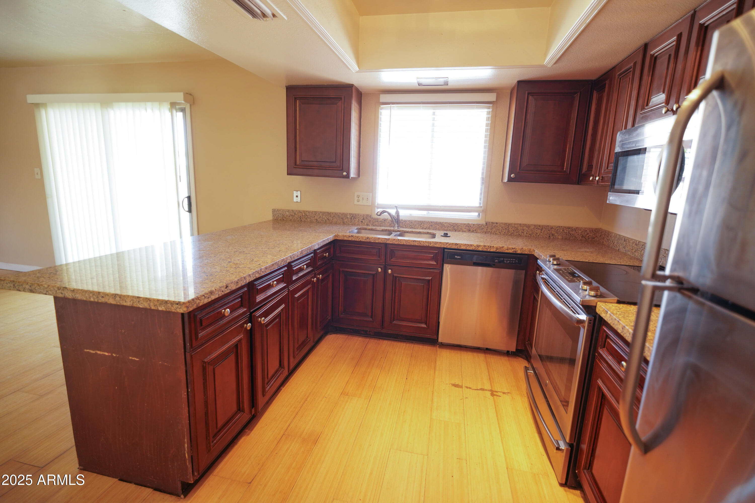 2620 West Irisado Circle Mesa, AZ 85202 - Photo 3 of 11 a kitchen with stainless steel appliances granite countertop a sink counter space and a window
