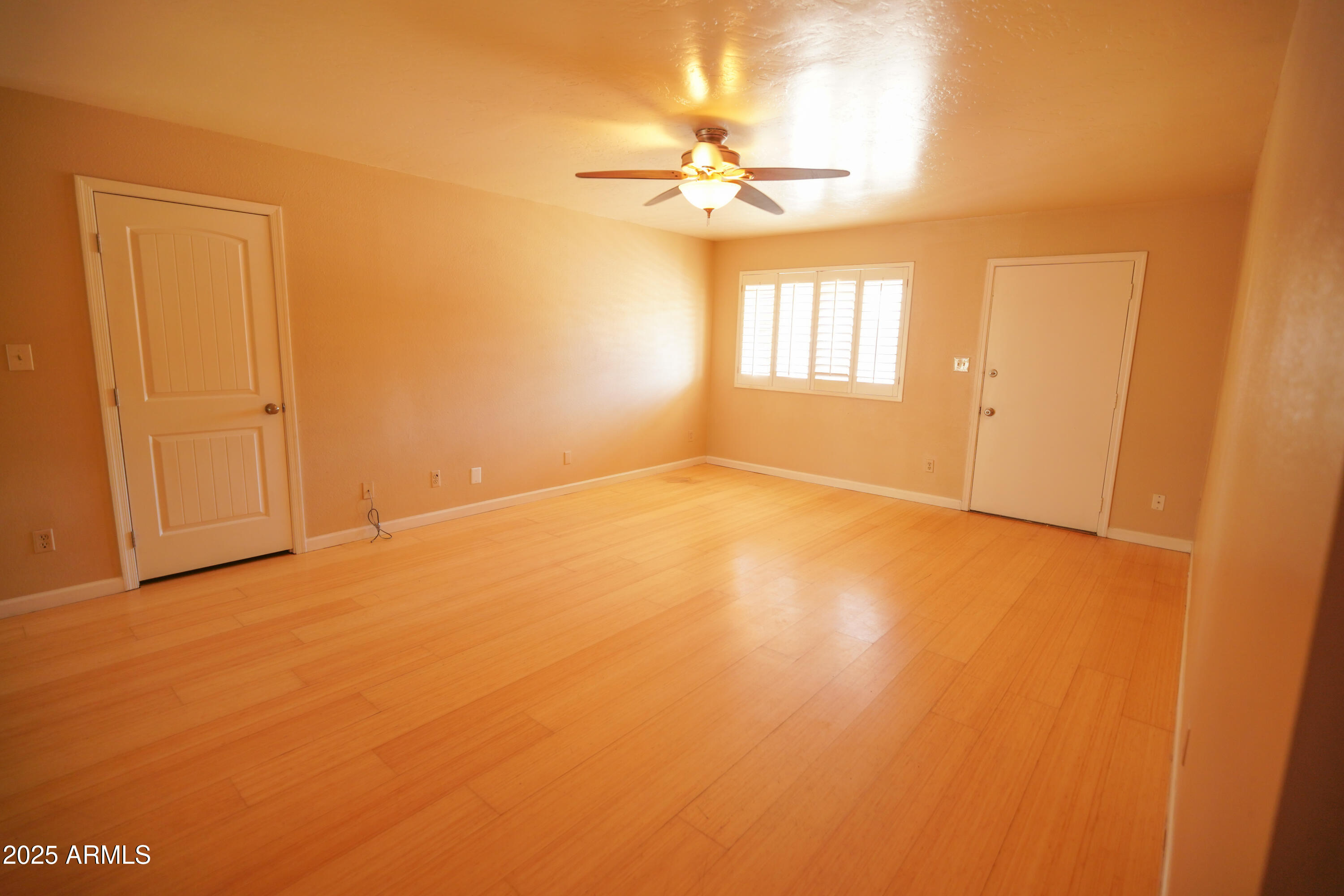 2620 West Irisado Circle Mesa, AZ 85202 - Photo 7 of 11 an empty room with a chandelier fan and windows