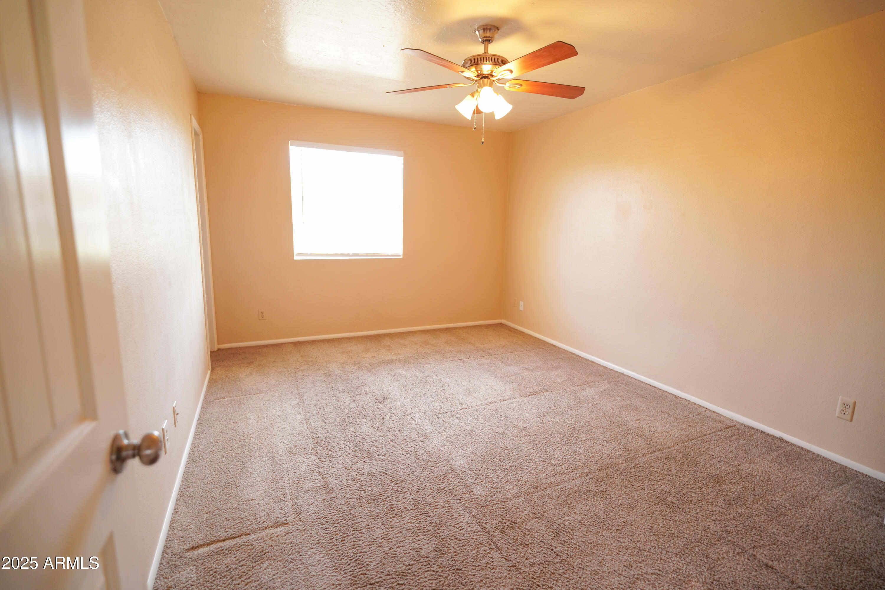 2620 West Irisado Circle Mesa, AZ 85202 - Photo 8 of 11 an empty room with windows and fan
