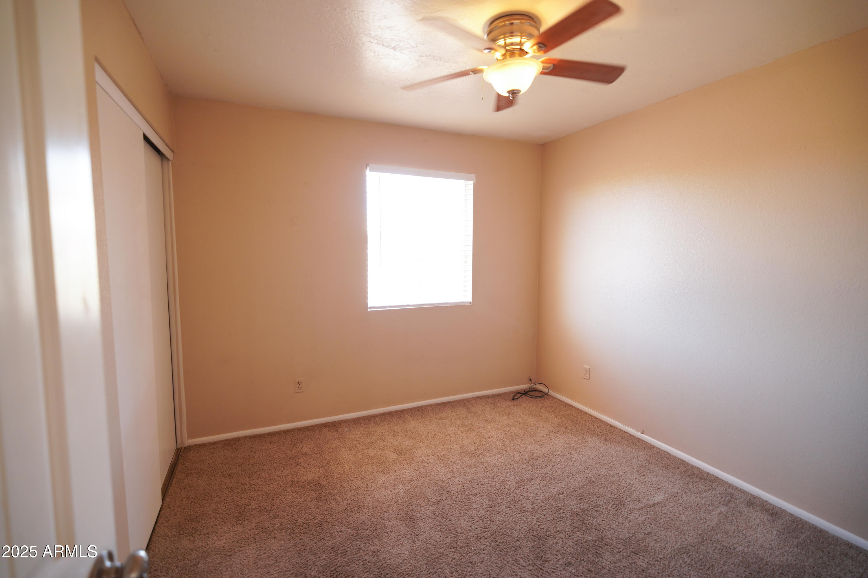 2620 West Irisado Circle Mesa, AZ 85202 - Photo 9 of 11 an empty room with a window and a fan