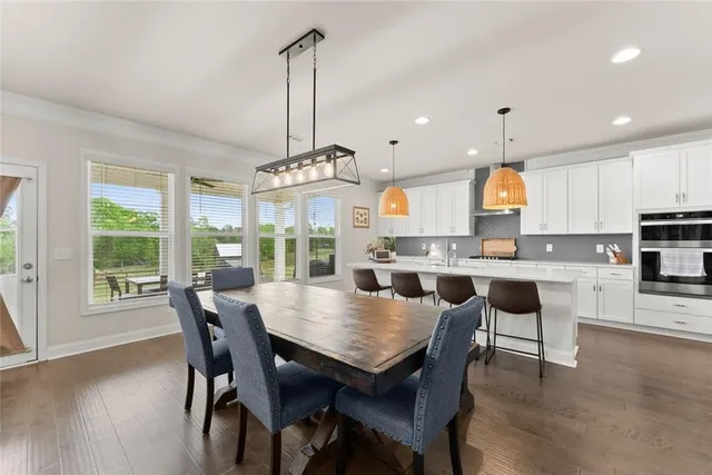 a view of a dining room and livingroom with furniture wooden floor a chandelier