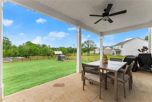 a view of a white house with a yard table and chairs