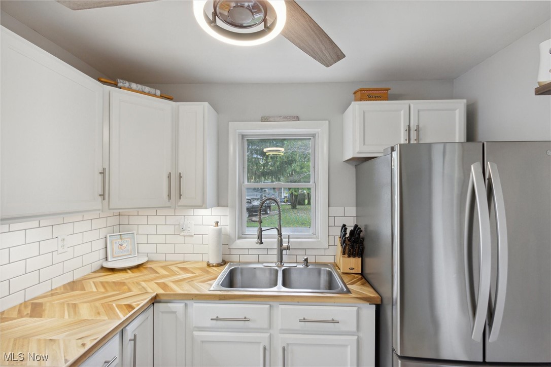 373 Erie Road Vermilion, OH 44089 - Photo 11 of 29 Kitchen featuring stainless steel fridge, white cabinetry, and sink