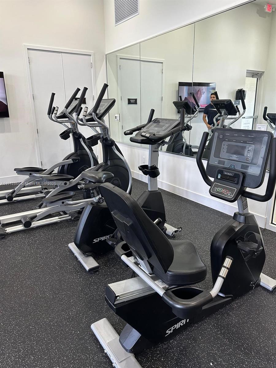12221 Northwest 23rd Place Miami, FL 33167 - Photo 19 of 19 a room with gym equipment and wooden floor