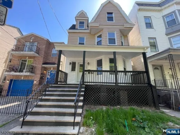 a view of a brick house with many windows and a gate
