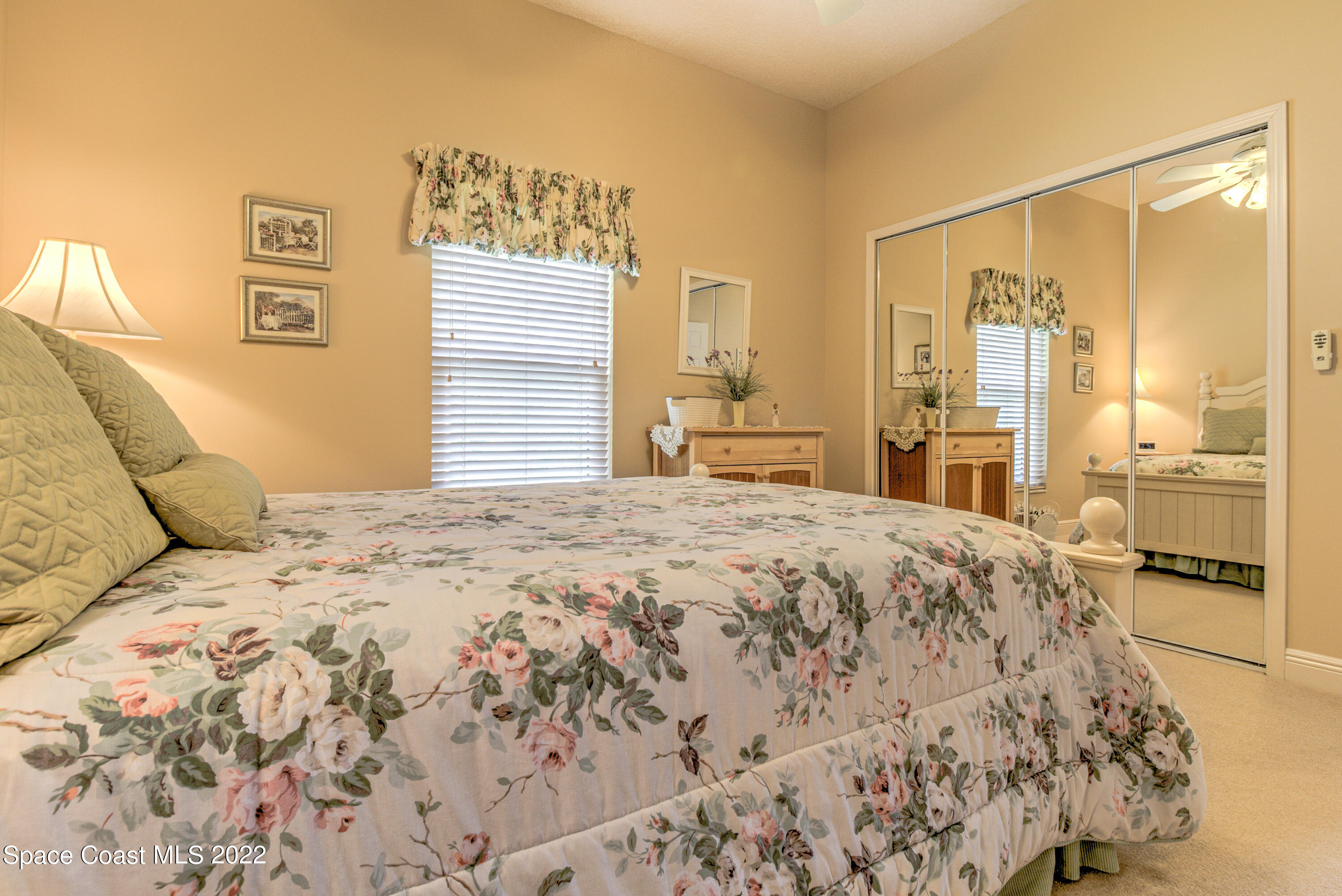 3415 Shady Run Road Melbourne, FL 32934 - Photo 24 of 45 a bedroom with a large bed and a chandelier