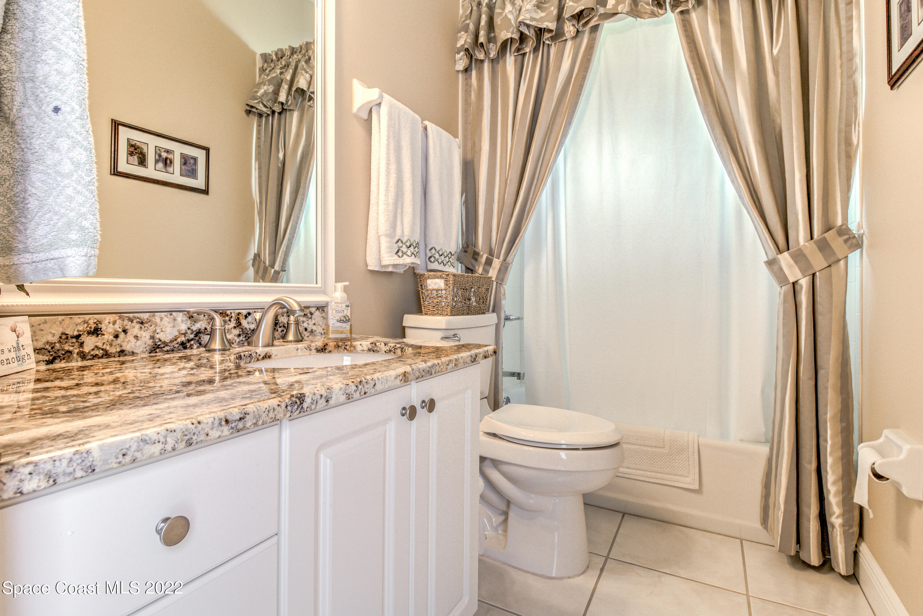 3415 Shady Run Road Melbourne, FL 32934 - Photo 26 of 45 a bathroom with a granite countertop sink and a toilet