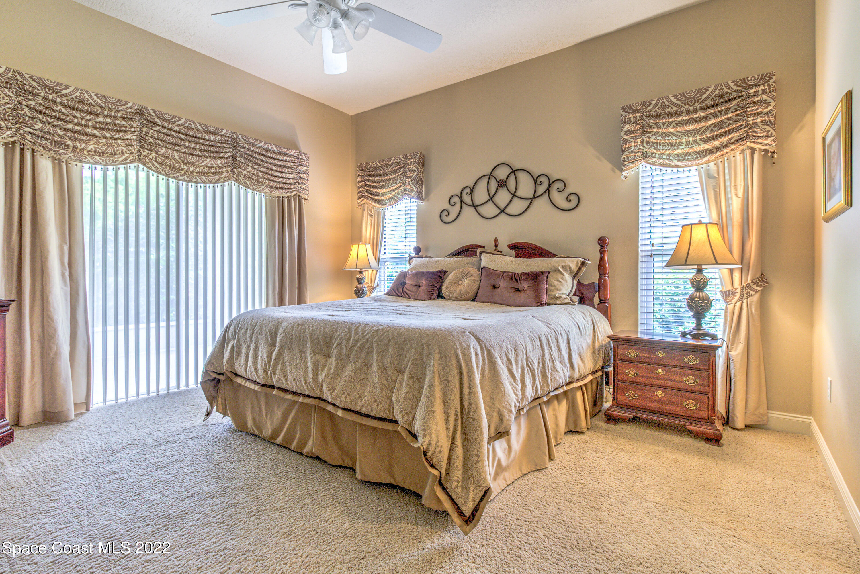 3415 Shady Run Road Melbourne, FL 32934 - Photo 8 of 45 a bedroom with a bed and a chandelier